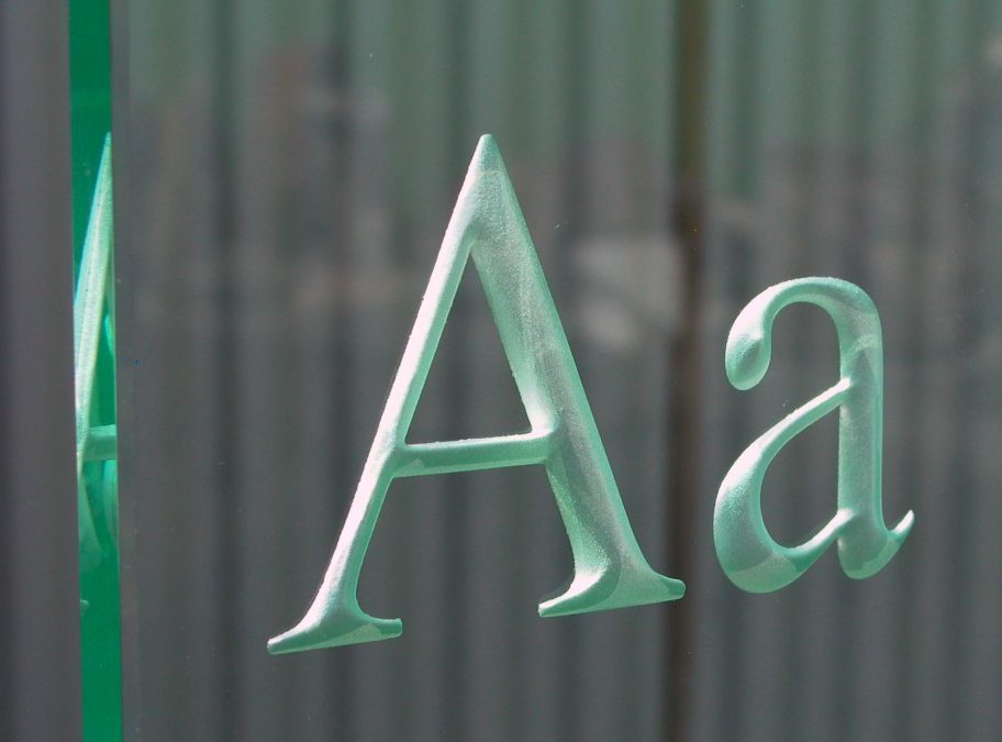 gestraalde letters in glas